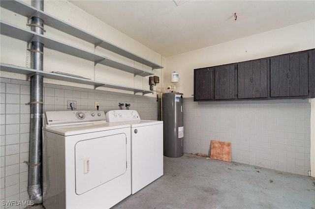 clothes washing area featuring laundry area, water heater, tile walls, and separate washer and dryer