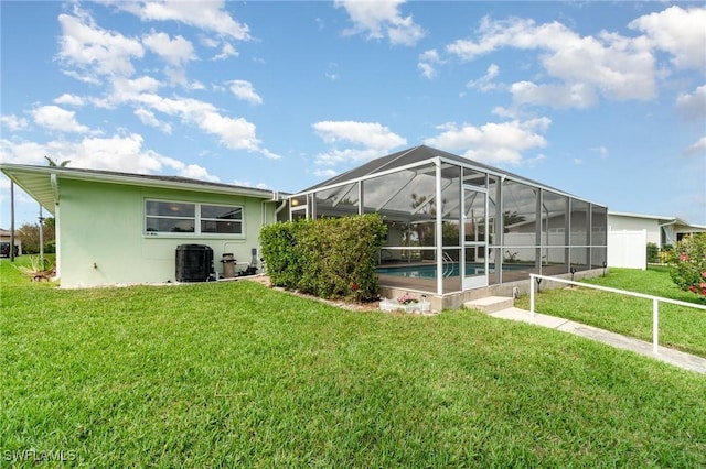 back of property with a yard, glass enclosure, an outdoor pool, and stucco siding