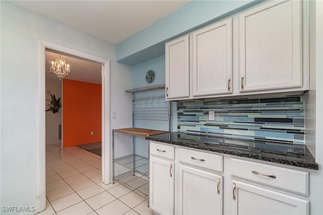 kitchen featuring light tile patterned flooring, white cabinets, open shelves, tasteful backsplash, and dark stone countertops