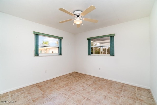 empty room featuring baseboards and a ceiling fan