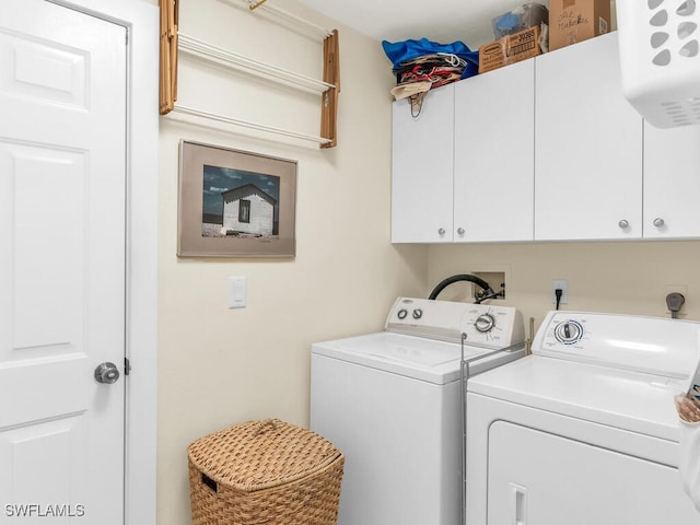 laundry area featuring washer and clothes dryer and cabinets