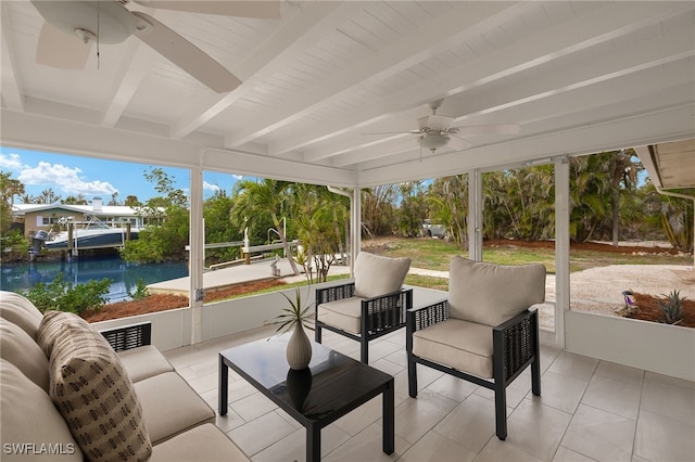 sunroom / solarium featuring a water view, ceiling fan, and beam ceiling