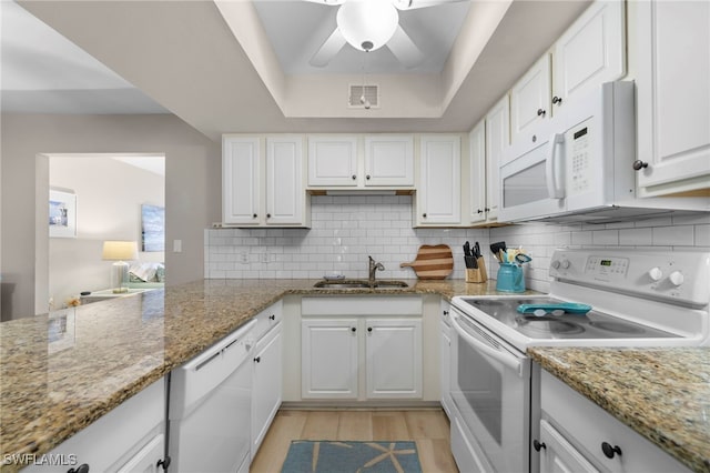 kitchen featuring sink, white appliances, light stone counters, and white cabinets