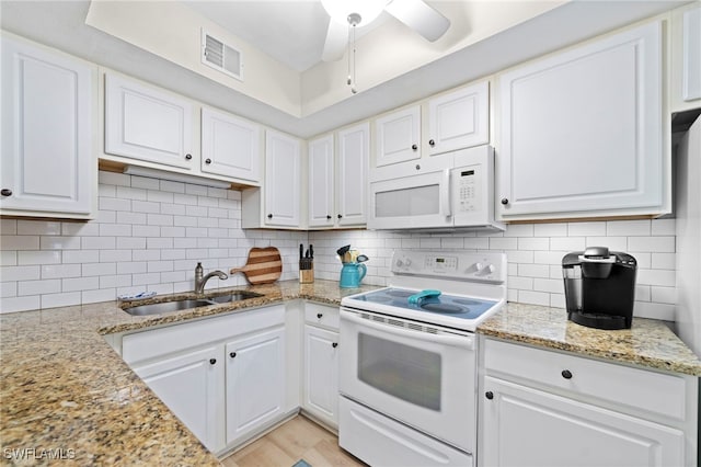 kitchen with white cabinetry, light stone countertops, sink, white appliances, and decorative backsplash