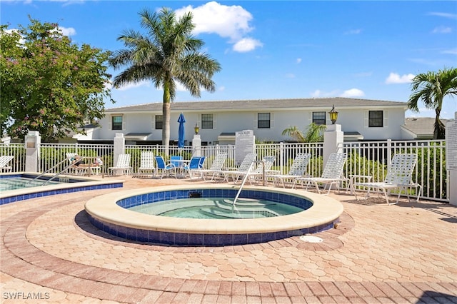 view of swimming pool featuring a hot tub