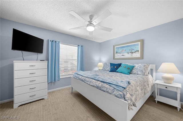 bedroom with light carpet, ceiling fan, and a textured ceiling