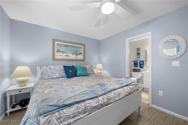 bedroom with a textured ceiling, carpet flooring, connected bathroom, and ceiling fan