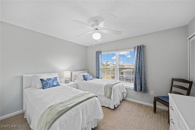 carpeted bedroom featuring ceiling fan and a textured ceiling