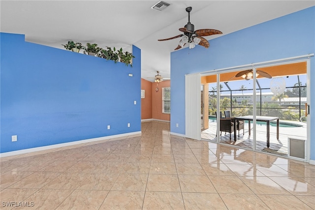 empty room with ceiling fan and a towering ceiling