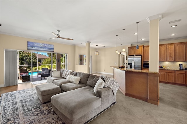 living room with visible vents, a ceiling fan, crown molding, ornate columns, and recessed lighting