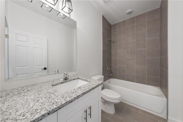 full bathroom featuring tiled shower / bath combo, vanity, toilet, and tile patterned floors