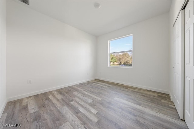 unfurnished bedroom with light hardwood / wood-style floors and a closet