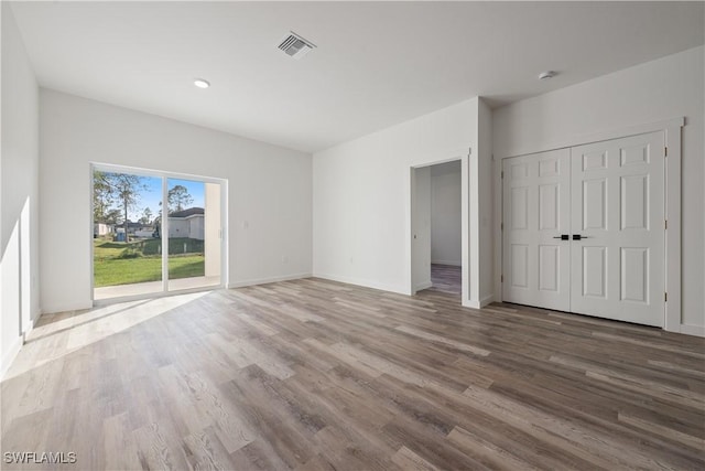 unfurnished bedroom featuring access to outside and wood-type flooring