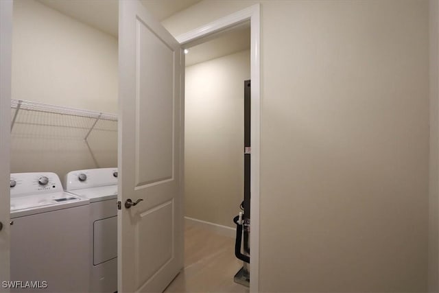 washroom with washing machine and dryer and light hardwood / wood-style flooring