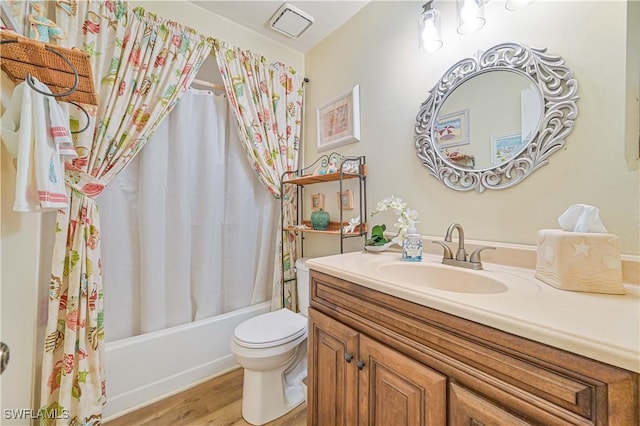 full bathroom featuring toilet, wood finished floors, visible vents, vanity, and shower / bath combination with curtain