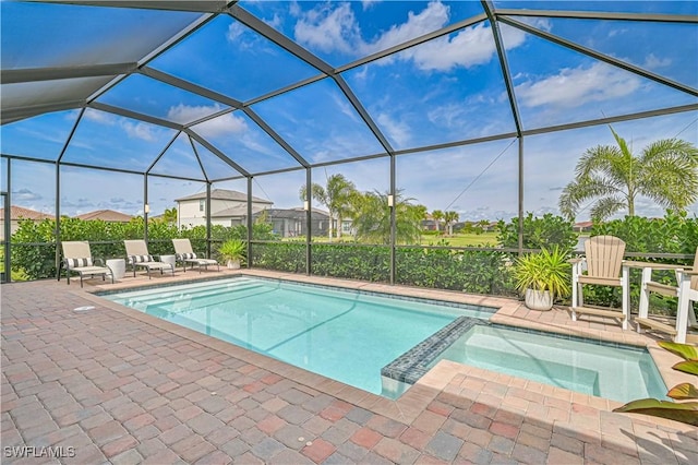 view of pool featuring a lanai, a pool with connected hot tub, and a patio