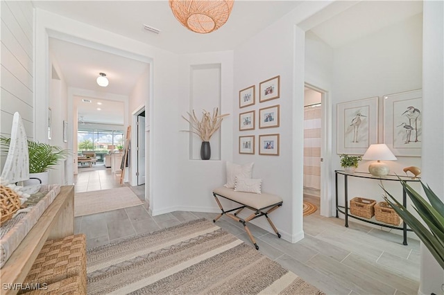 hallway with baseboards and visible vents