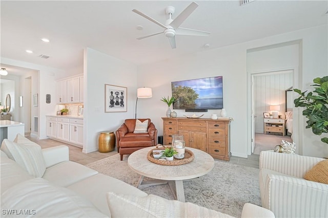 living room featuring a ceiling fan, recessed lighting, light tile patterned flooring, and visible vents