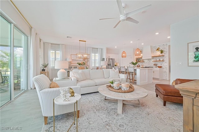 living room with recessed lighting, visible vents, and ceiling fan with notable chandelier