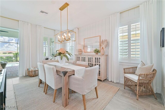 dining area featuring a healthy amount of sunlight, light tile patterned floors, visible vents, and a notable chandelier