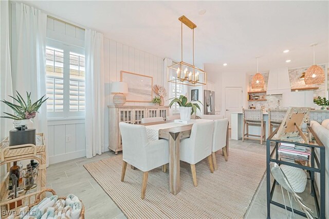 dining room with recessed lighting, light wood finished floors, and an inviting chandelier