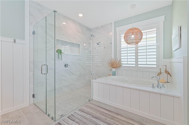 bathroom with a garden tub and a marble finish shower