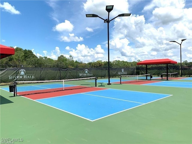 view of tennis court with community basketball court and fence