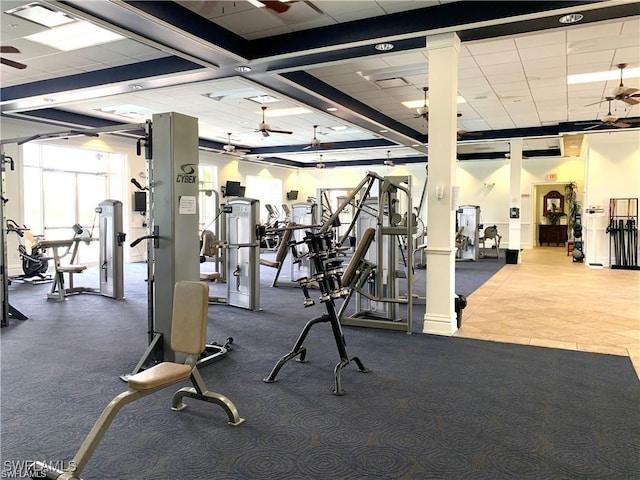 exercise room featuring a ceiling fan, a drop ceiling, and visible vents