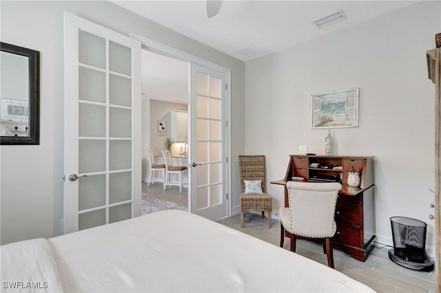 bedroom featuring french doors and light hardwood / wood-style flooring