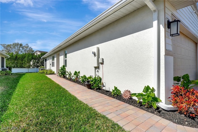 view of home's exterior featuring a garage and a yard