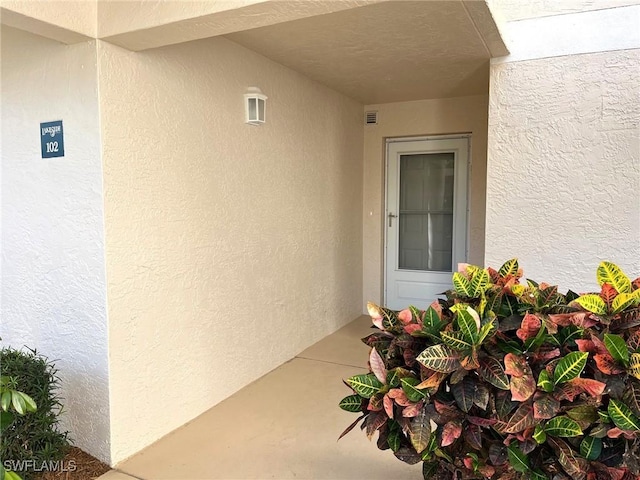 view of exterior entry with stucco siding