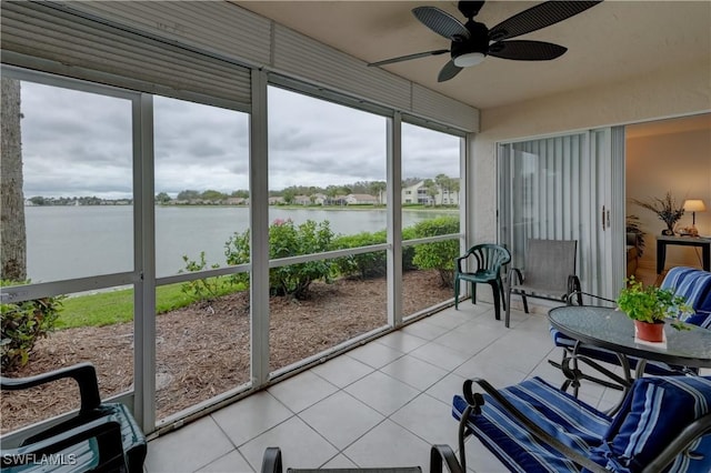 sunroom / solarium with a water view and ceiling fan