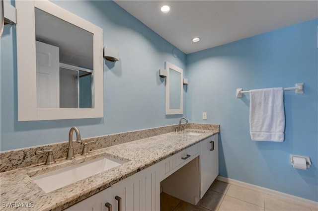 bathroom featuring recessed lighting, baseboards, a sink, and tile patterned floors