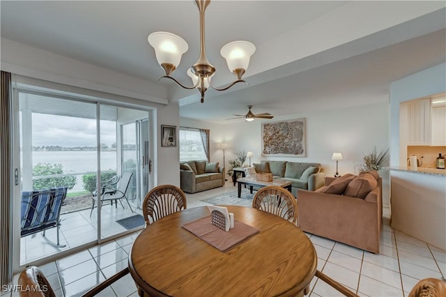 dining area featuring light tile patterned flooring and ceiling fan with notable chandelier