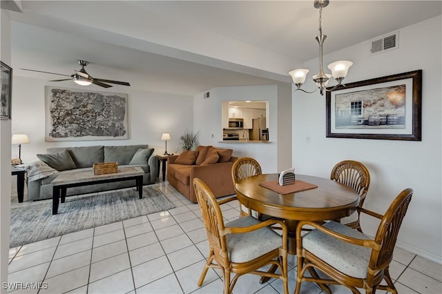 dining room with ceiling fan with notable chandelier, light tile patterned flooring, and visible vents