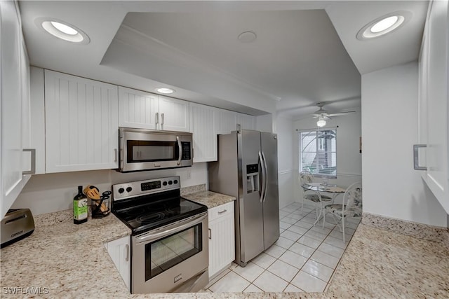 kitchen featuring light tile patterned floors, white cabinets, appliances with stainless steel finishes, light stone countertops, and recessed lighting