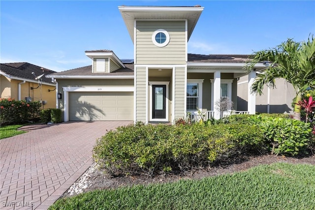 view of front facade featuring a garage and decorative driveway