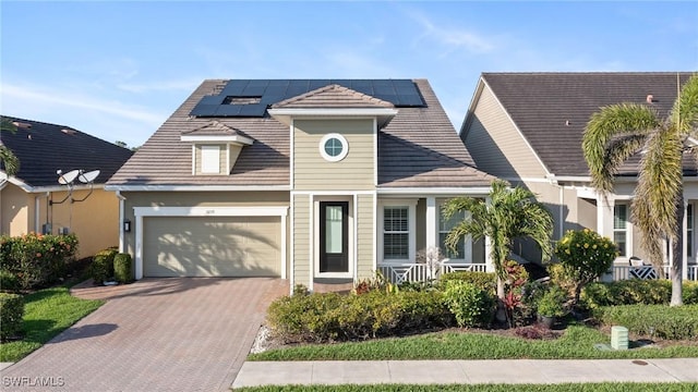3275 Pilot Cir, Naples, FL 34120 - view of front facade featuring roof mounted solar panels and decorative driveway