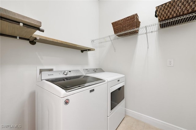 laundry room featuring laundry area, baseboards, and washing machine and clothes dryer