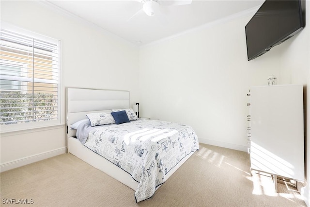 carpeted bedroom featuring ceiling fan, baseboards, and crown molding