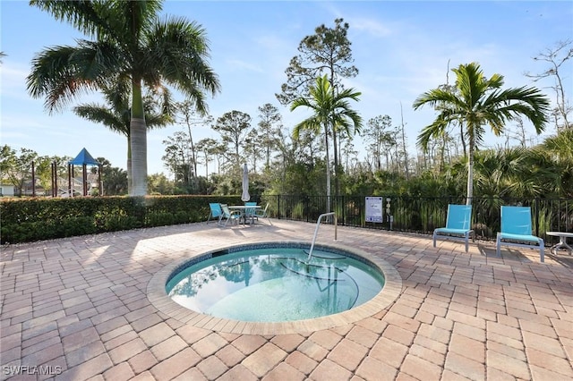 view of pool featuring a community hot tub, a patio area, and fence