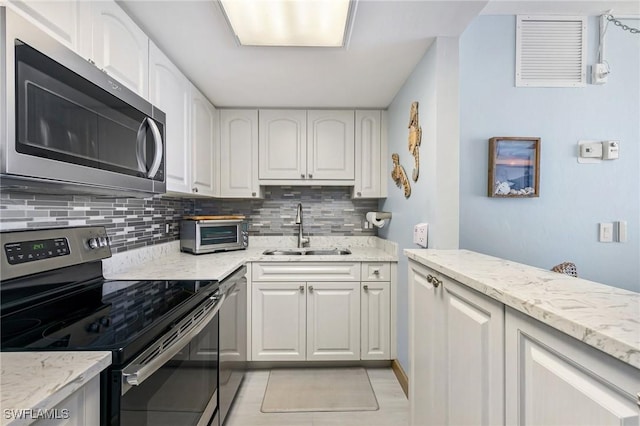 180 Seaview Ct Unit 911, Marco Island, FL 34145 - kitchen featuring stainless steel appliances, a sink, backsplash, and light stone counters