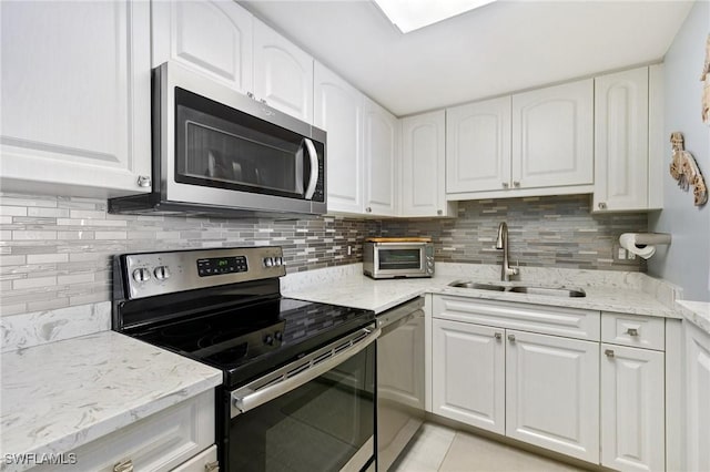 180 Seaview Ct Unit 911, Marco Island, FL 34145 - kitchen featuring stainless steel appliances, a sink, light stone countertops, light tile patterned floors, and decorative backsplash