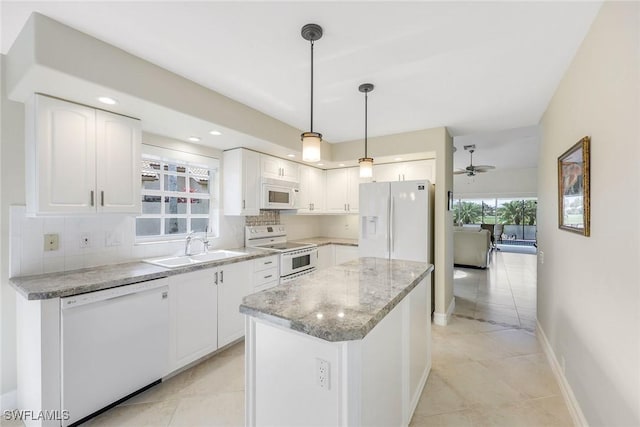 kitchen featuring white appliances, white cabinets, decorative light fixtures, a kitchen island, and sink