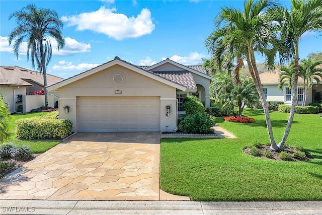 view of front of house with a tile roof, stucco siding, a garage, driveway, and a front lawn