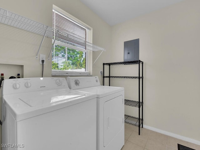 clothes washing area with visible vents, separate washer and dryer, laundry area, electric panel, and baseboards