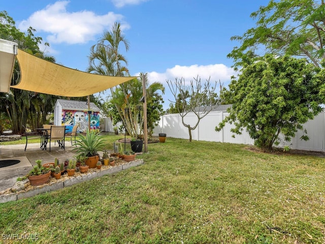 view of yard featuring an outbuilding, a patio, a storage shed, and a fenced backyard