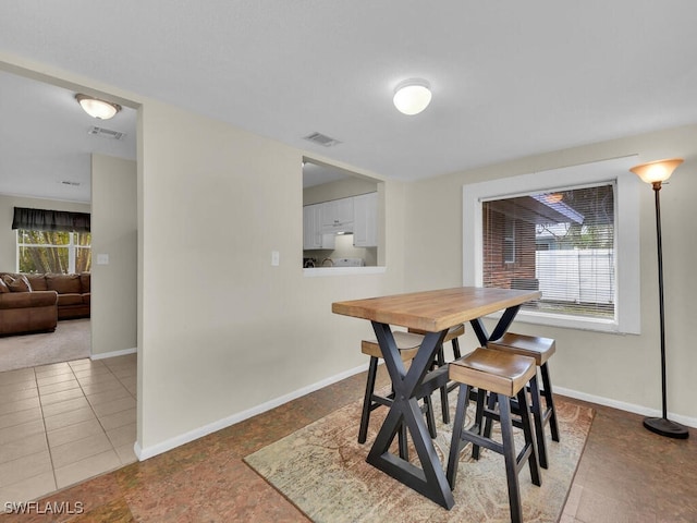 dining area featuring tile patterned flooring, visible vents, and baseboards