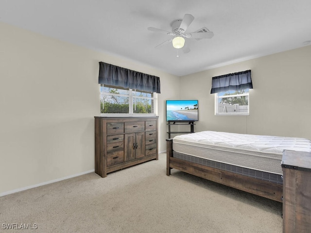 bedroom featuring a ceiling fan, light colored carpet, and baseboards