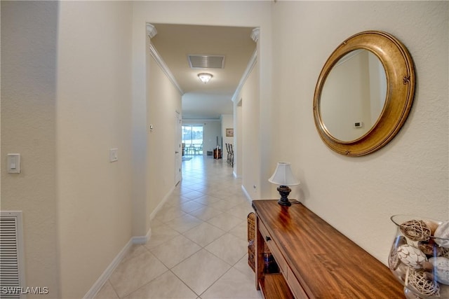 hallway featuring light tile patterned floors, baseboards, visible vents, and crown molding